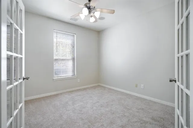 an empty room with windows and fan
