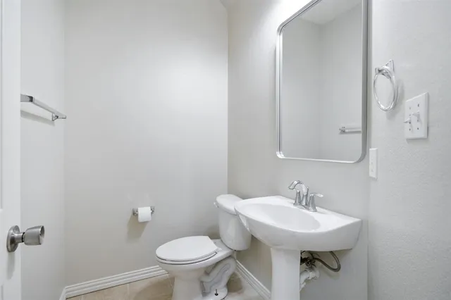 a bathroom with a sink toilet and a mirror