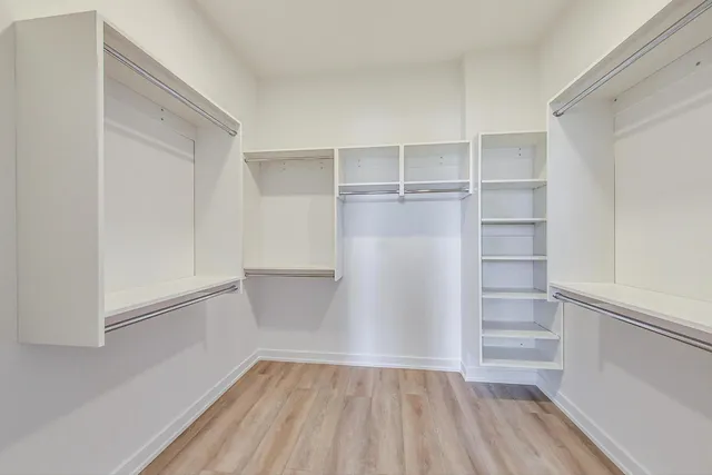 a view of walk in closet with empty racks