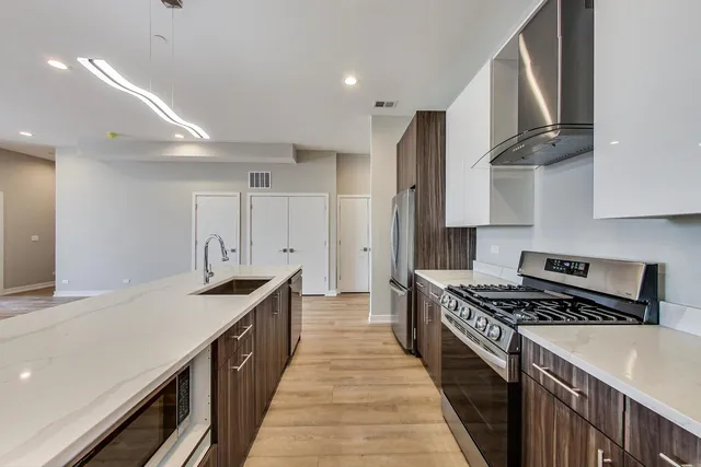 a kitchen with stainless steel appliances a sink stove and cabinets