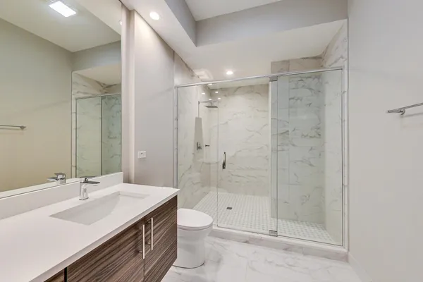 a bathroom with a sink a toilet and shower