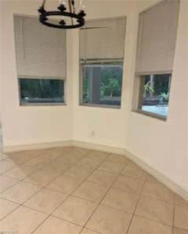 2841 12th Avenue Northeast Naples, FL 34120 - Photo 3 of 9 Spare room with a chandelier and light tile patterned floors