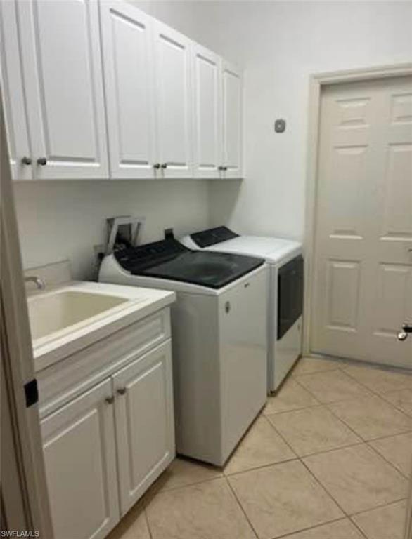 2841 12th Avenue Northeast Naples, FL 34120 - Photo 6 of 9 Laundry area with cabinet space, light tile patterned flooring, and washing machine and clothes dryer