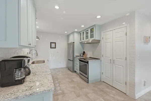 a kitchen with stainless steel appliances granite countertop a stove a sink and a refrigerator