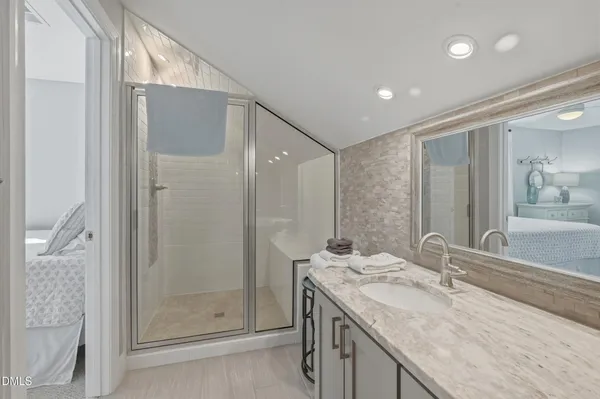 a bathroom with a granite countertop sink mirror and shower