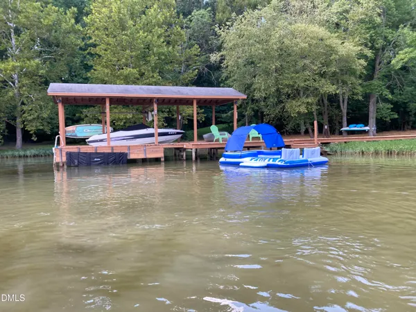 a view of pool with lawn chairs and plants