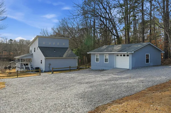 a front view of house with yard and trees in the background