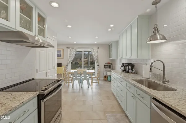 a kitchen with granite countertop a sink stainless steel appliances and cabinets