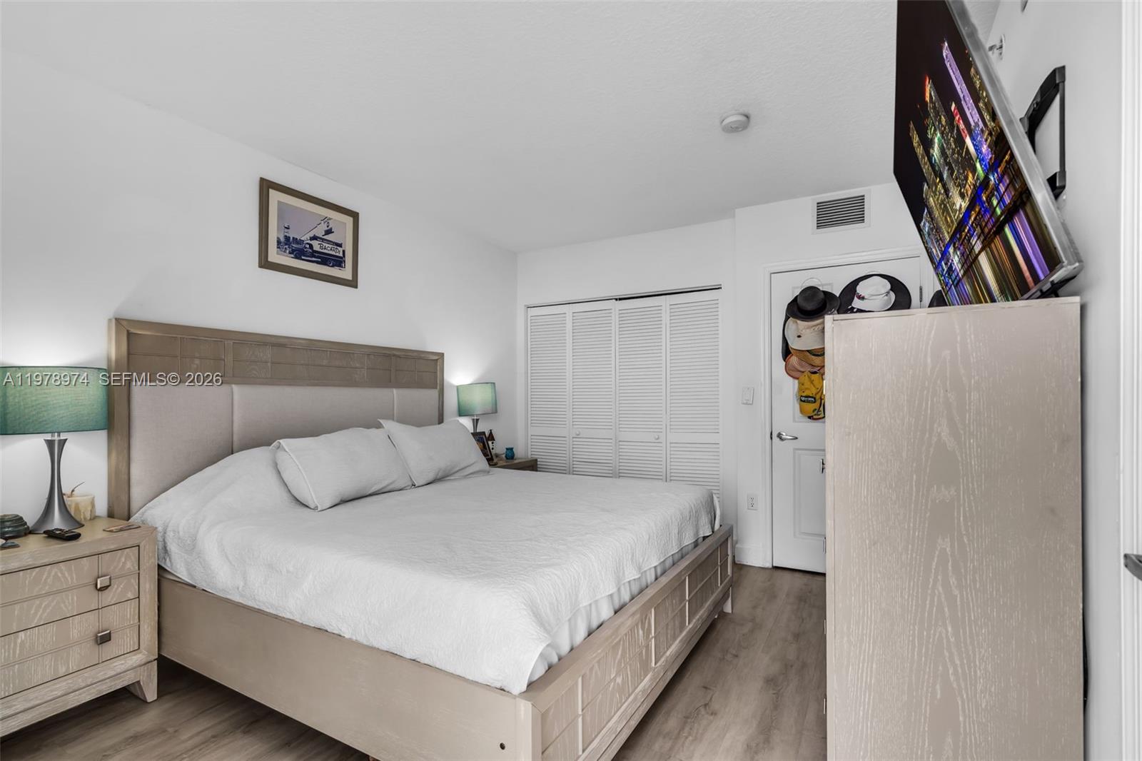 900 Southwest 8th Street, Unit 1603 Miami, FL 33130 - Photo 12 of 32 a bedroom with a bed and a flat tv screen on the dresser