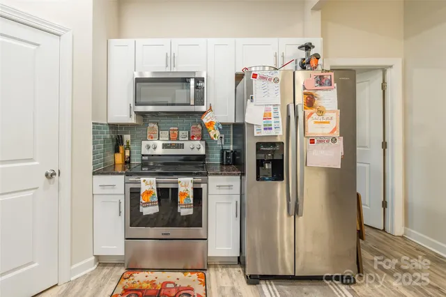 a kitchen with stainless steel appliances granite countertop a refrigerator and a stove