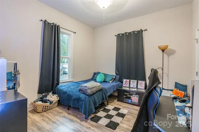 a bedroom with furniture and a wooden floor