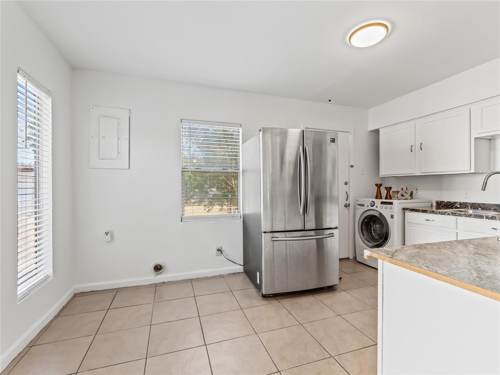 826 Ryan Road Dallas, TX 75224 - Photo 12 of 34 a kitchen with a refrigerator and white cabinets