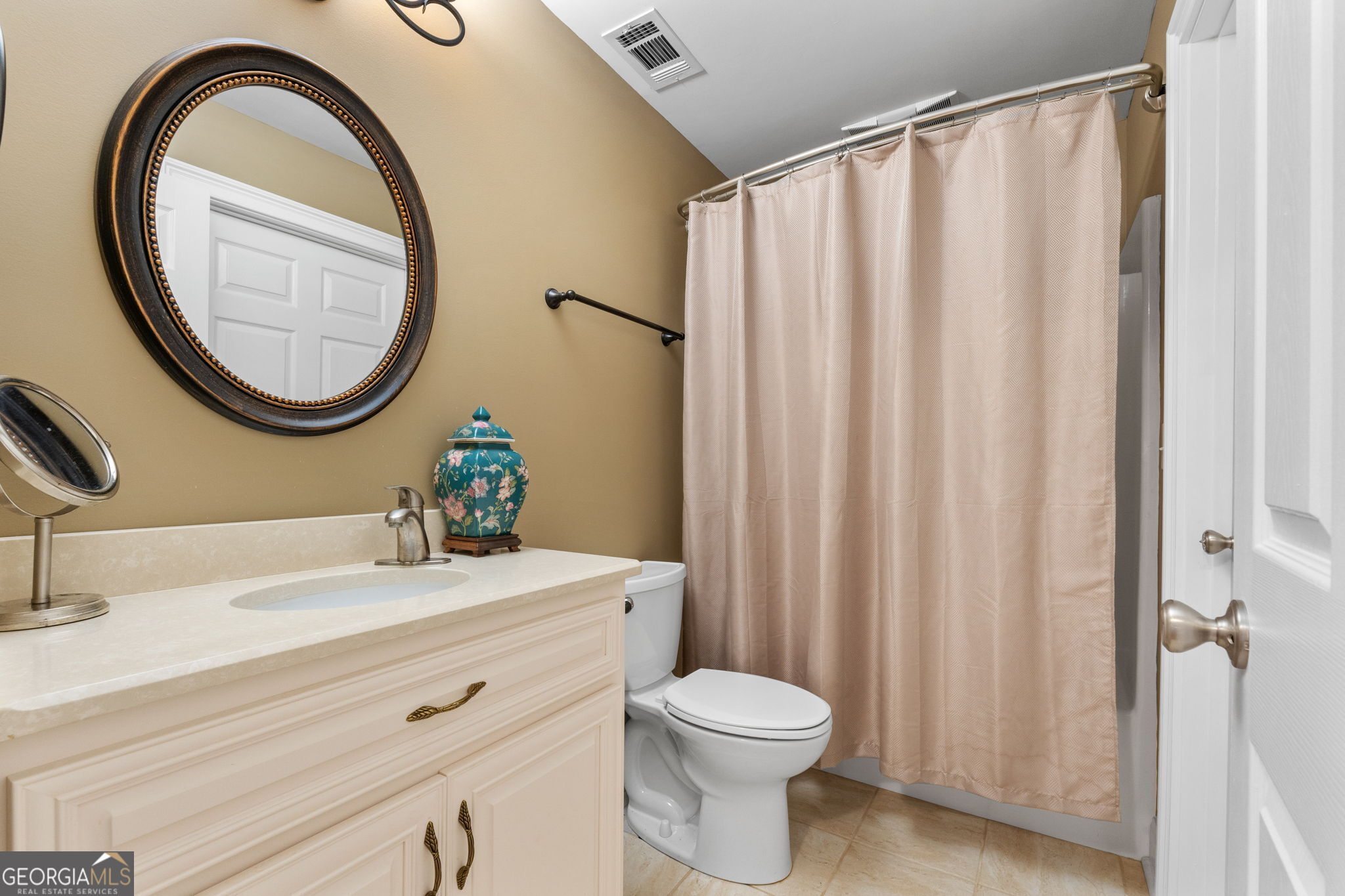 735 Firetower Road Thomaston, GA 30286 - Photo 23 of 112 a bathroom with a sink a mirror a toilet and a window