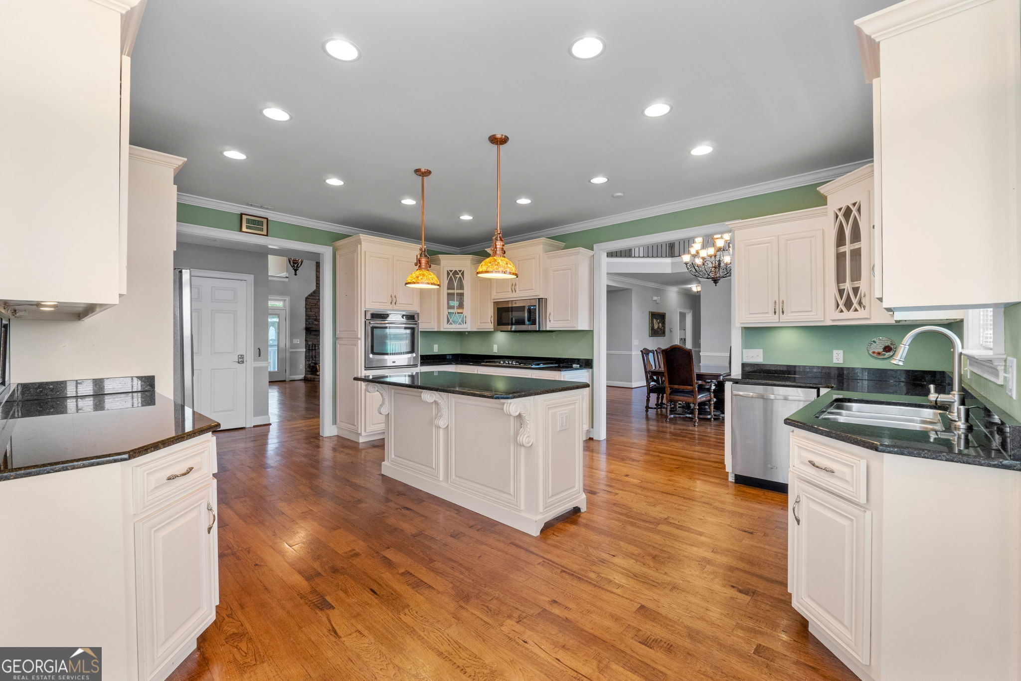 735 Firetower Road Thomaston, GA 30286 - Photo 79 of 112 a kitchen with stainless steel appliances kitchen island granite countertop a stove top oven a sink a refrigerator and white cabinets with wooden floor