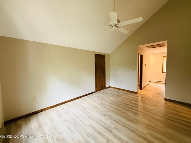 a view of an empty room with wooden floor