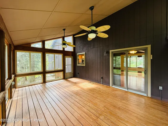 a view of a room with a ceiling fan and wooden floor