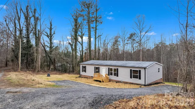 a view of a house with backyard and trees