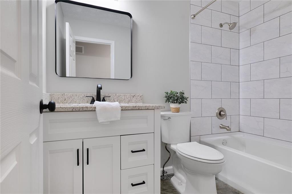 232 Barrett Springs Way Canton, GA 30115 - Photo 12 of 29 a bathroom with a toilet a sink a vanity and mirror