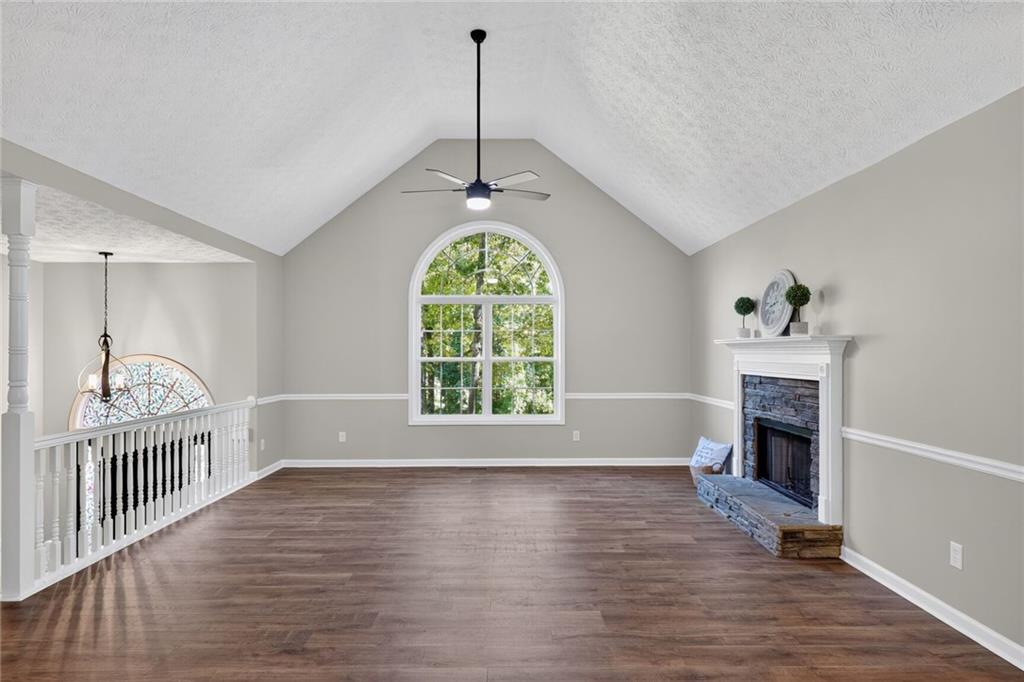 232 Barrett Springs Way Canton, GA 30115 - Photo 5 of 29 an empty room with wooden floor a fireplace and windows
