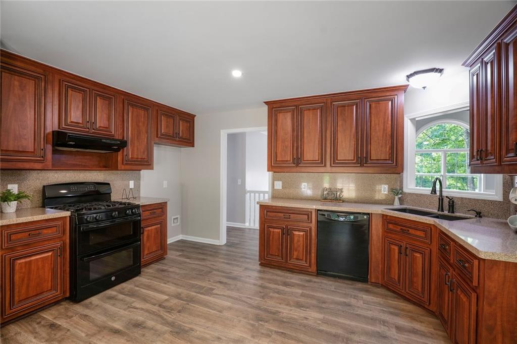 232 Barrett Springs Way Canton, GA 30115 - Photo 9 of 29 a kitchen with stainless steel appliances granite countertop wooden cabinets a sink and a stove