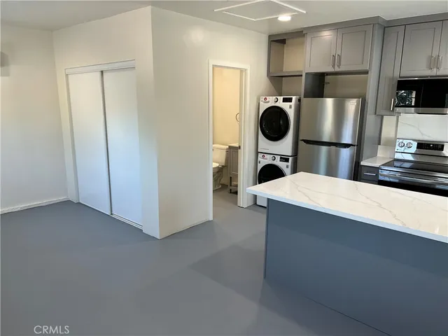 a kitchen with stainless steel appliances a refrigerator a stove a microwave and wooden cabinets