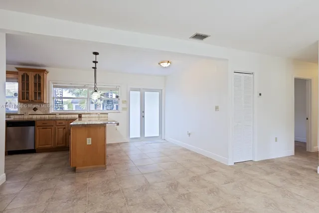 a large white kitchen with a sink and dishwasher a stove top oven