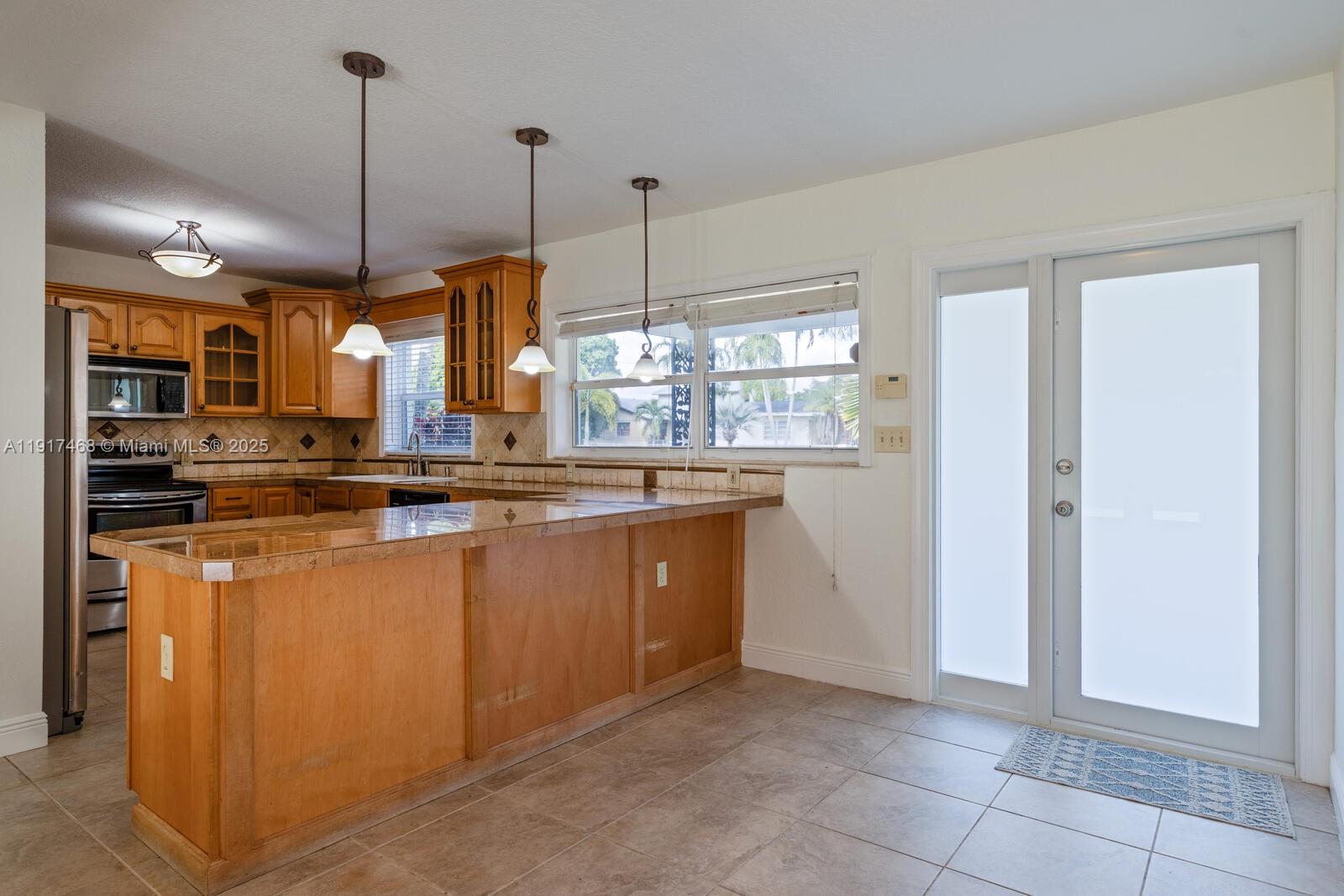 524 Northwest 14th Street Homestead, FL 33030 - Photo 20 of 37 a kitchen with stainless steel appliances granite countertop a refrigerator a sink a stove and a wooden floors