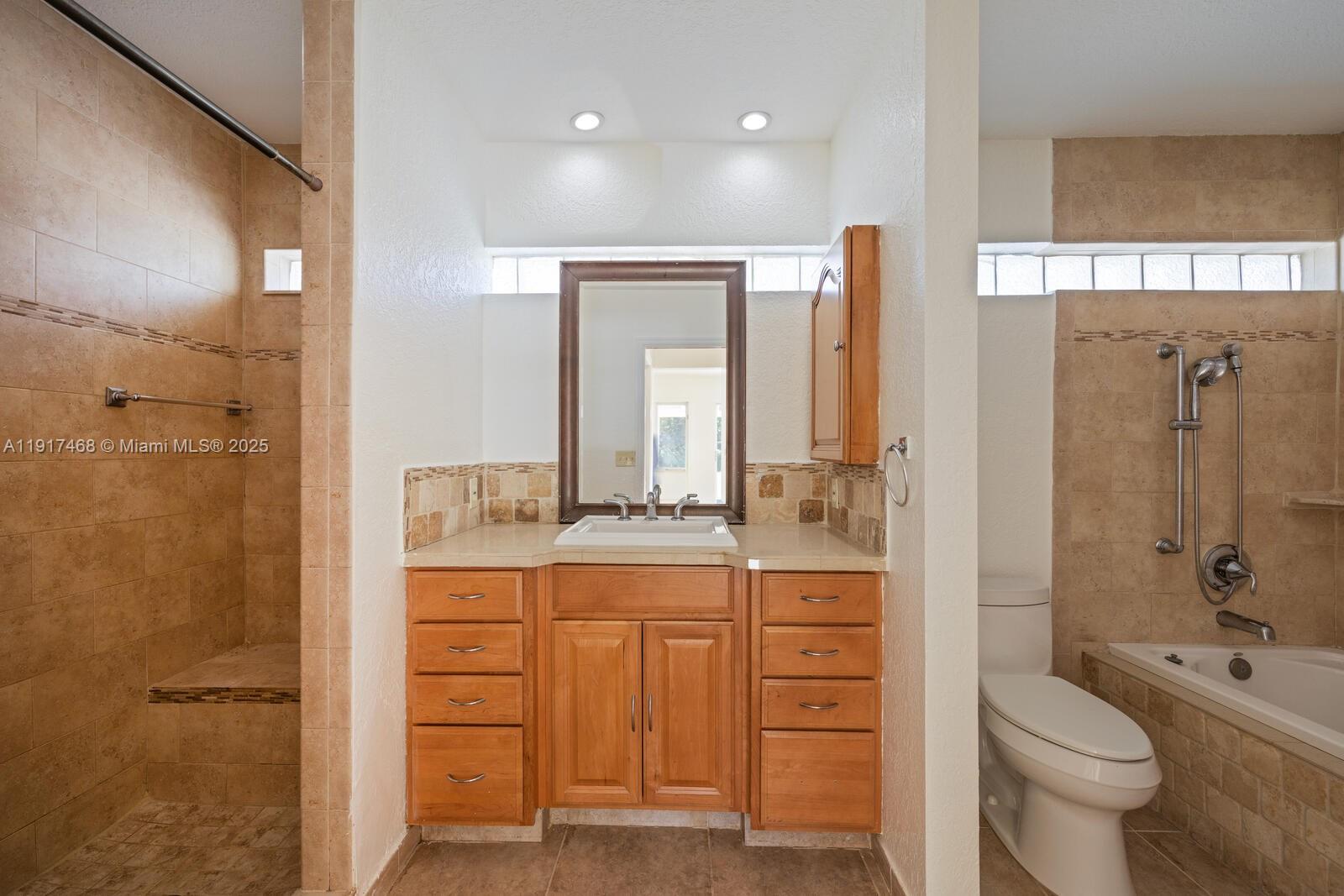 524 Northwest 14th Street Homestead, FL 33030 - Photo 26 of 37 a bathroom with a granite countertop sink toilet a large mirror a shower and a bathtub