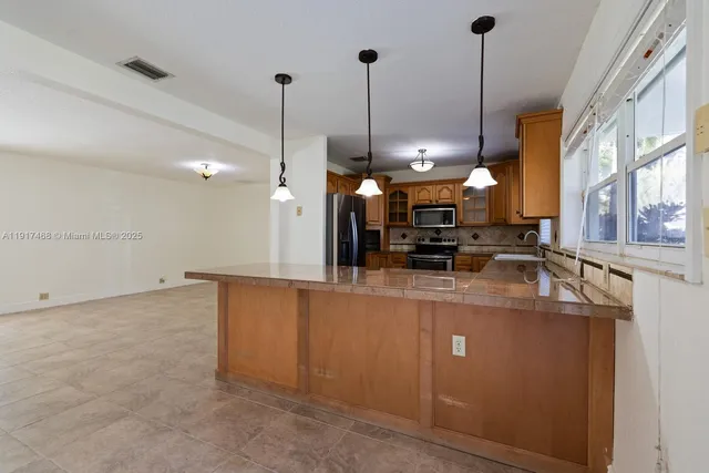 a view of a kitchen with stainless steel appliances granite countertop cabinets and a wooden floor