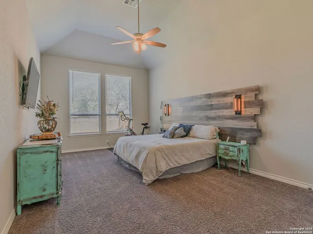 a spacious bedroom with a bed chandelier and a window