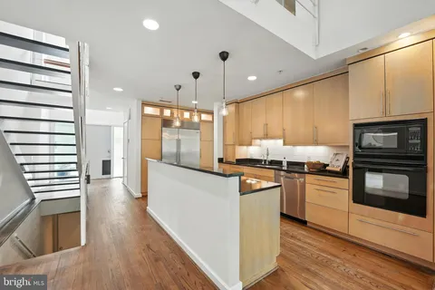 a view of kitchen with wooden floor and electronic appliances