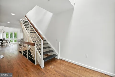 a large kitchen with a sink a counter space stainless steel appliances and cabinets
