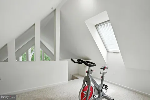 en view of an empty room with wooden floor and a window