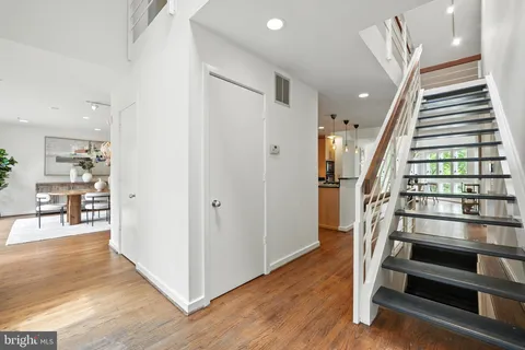 a dining room with wooden floor a chandelier a wooden table and chairs