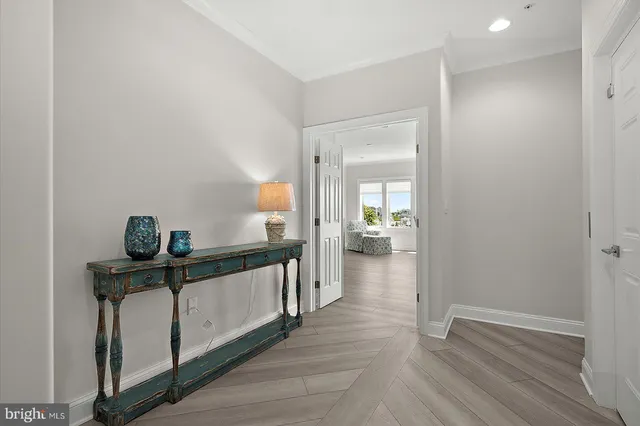 a kitchen with a dining table chairs wooden floor cabinets appliances and a window