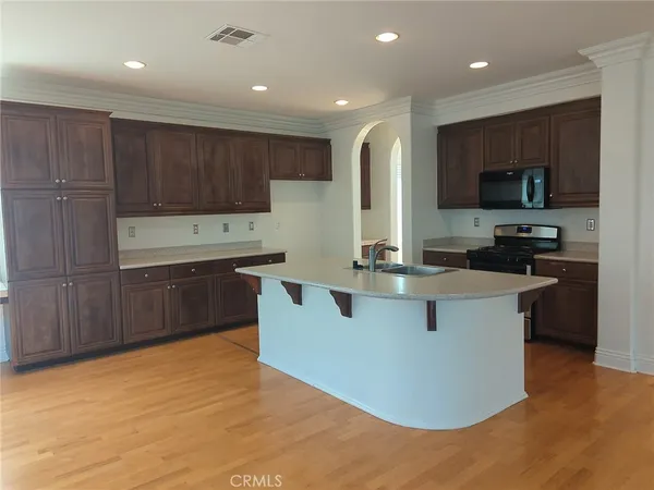 a kitchen with kitchen island a sink a stove a refrigerator and a oven