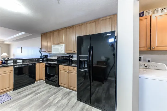 a kitchen with granite countertop wooden cabinets and stainless steel appliances