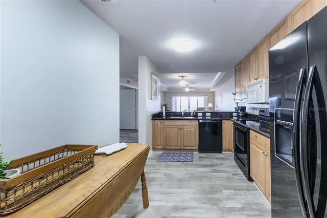 a kitchen with granite countertop wooden cabinets stainless steel appliances a sink and a window