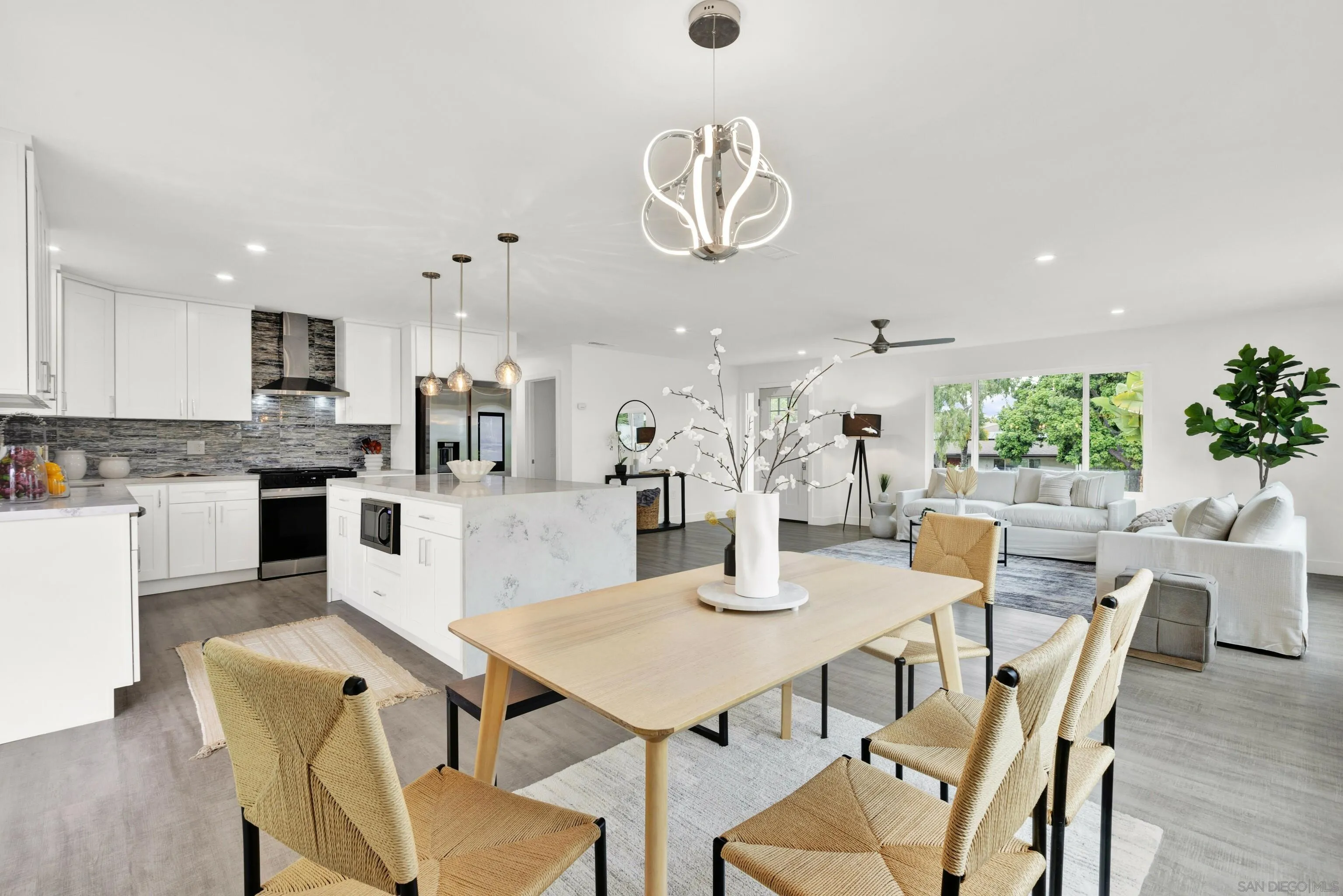 2250 Ivy Road Oceanside, CA 92054 - Photo 13 of 30 a dining room with wooden floor a chandelier a wooden table and chairs