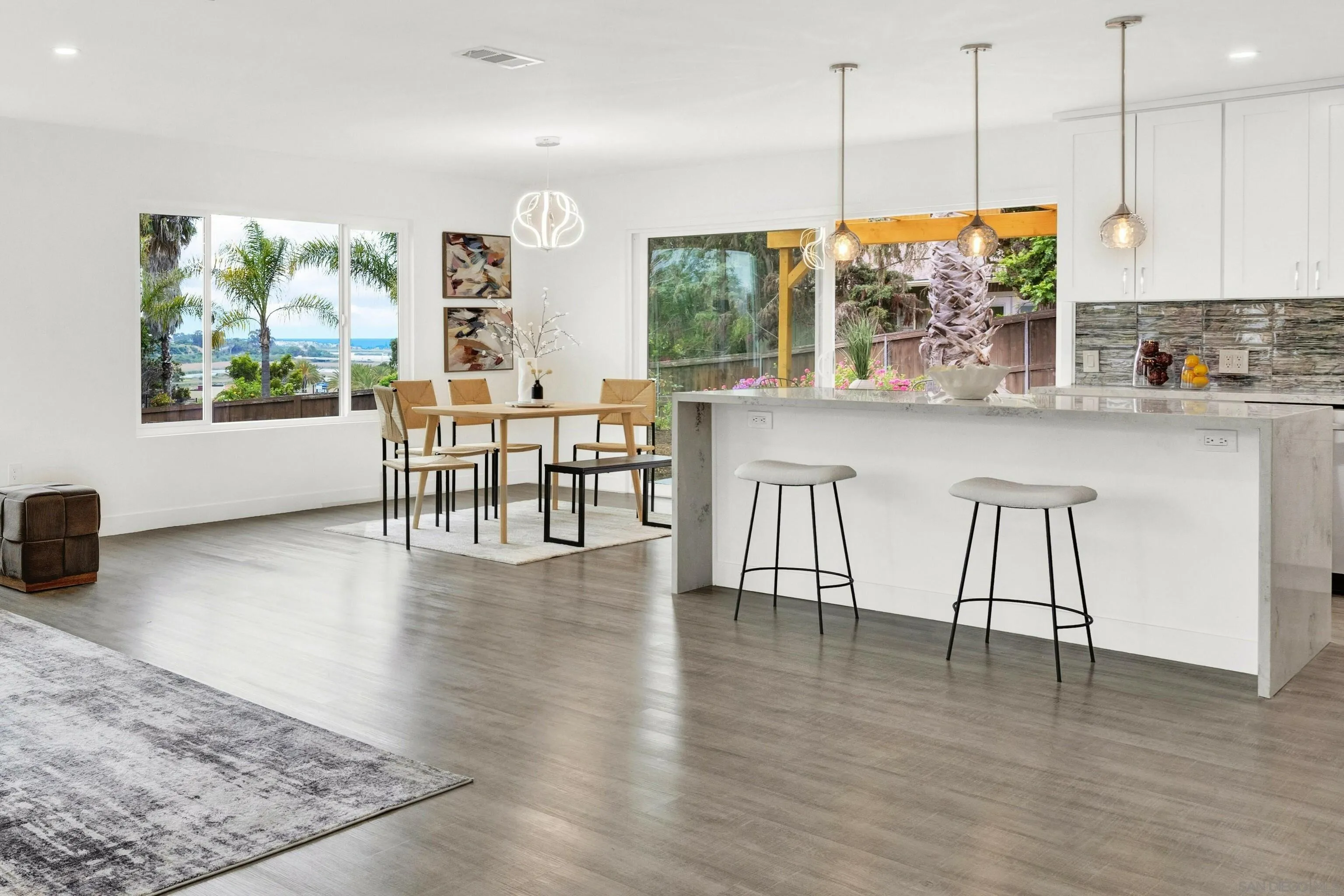 2250 Ivy Road Oceanside, CA 92054 - Photo 5 of 30 a dining room with wooden floor a chandelier a glass table and chairs