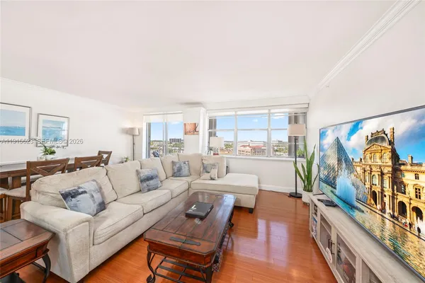 a living room with furniture and a view of kitchen