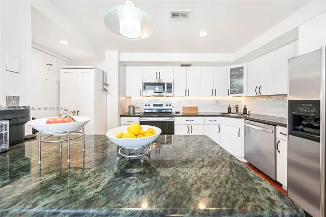 a kitchen with a dining table chairs and kitchen view