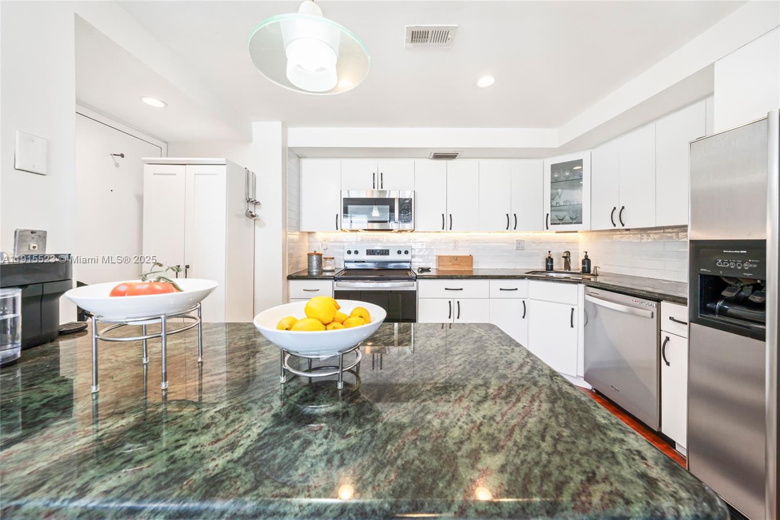 2100 Sans Souci Boulevard, Unit B1006 North Miami, FL 33181 - Photo 13 of 40 a kitchen with a dining table chairs and kitchen view