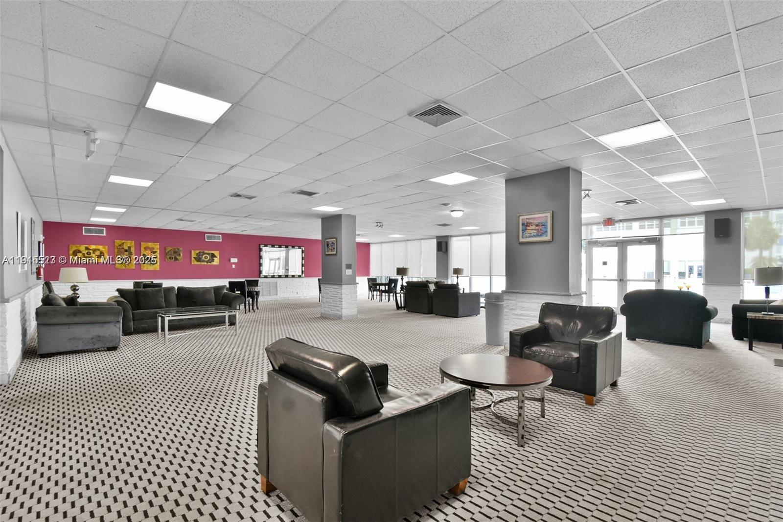 2100 Sans Souci Boulevard, Unit B1006 North Miami, FL 33181 - Photo 36 of 40 a living room with furniture a rug and a chandelier