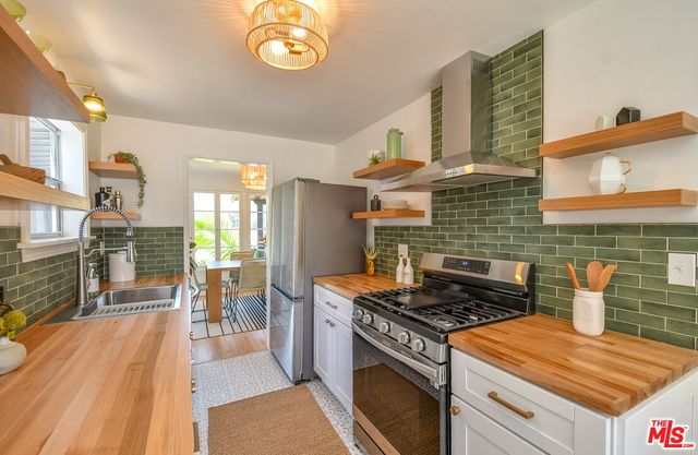 a stove top oven sitting inside of a kitchen