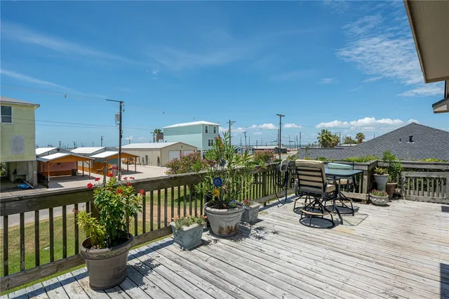 a view of a balcony with chairs and wooden floor