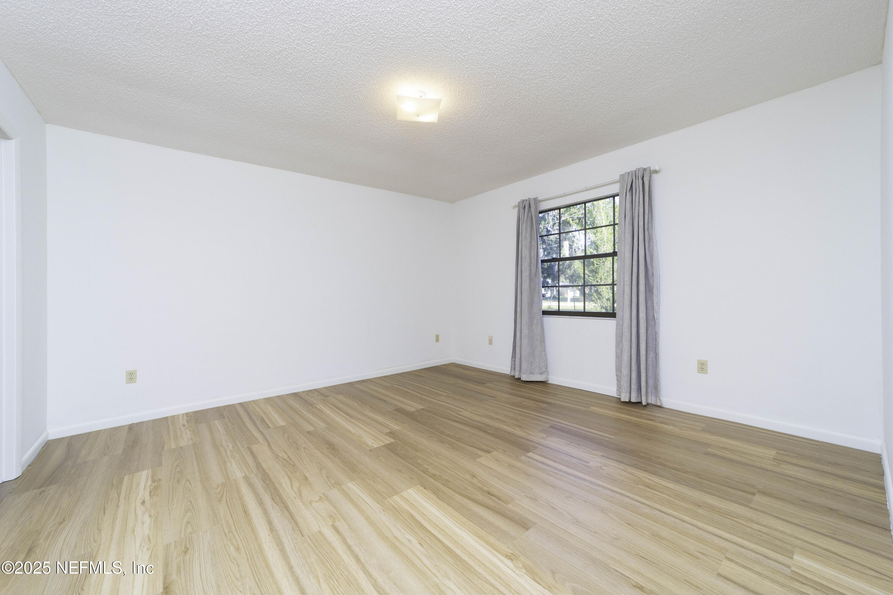 103 Indian Mound Road Satsuma, FL 32189 - Photo 17 of 36 a view of an empty room with wooden floor and a window