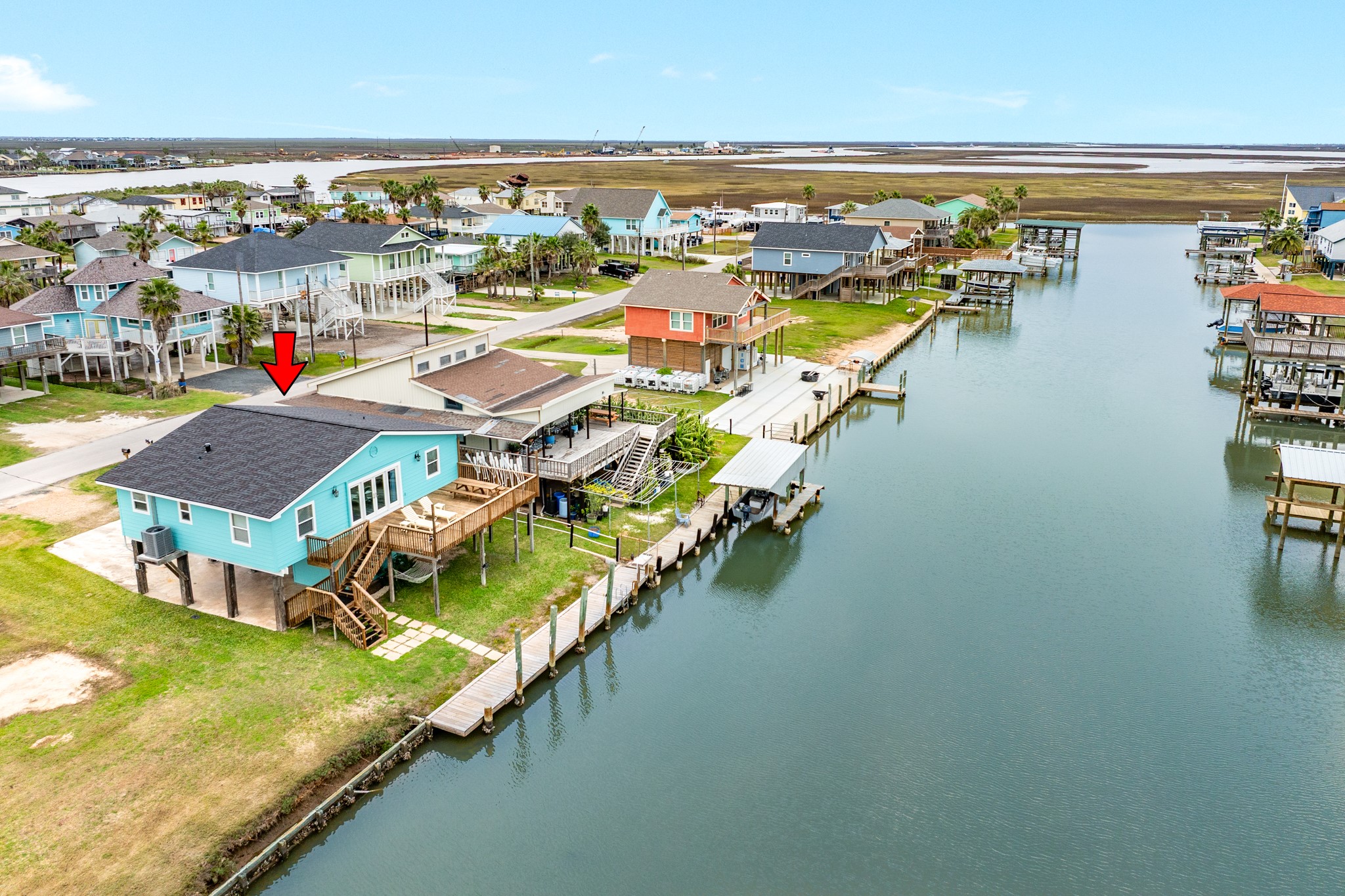 an aerial view of residential houses with outdoor space and ocean view
