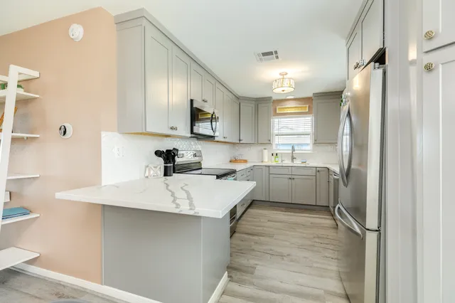 a kitchen with white cabinets and stainless steel appliances