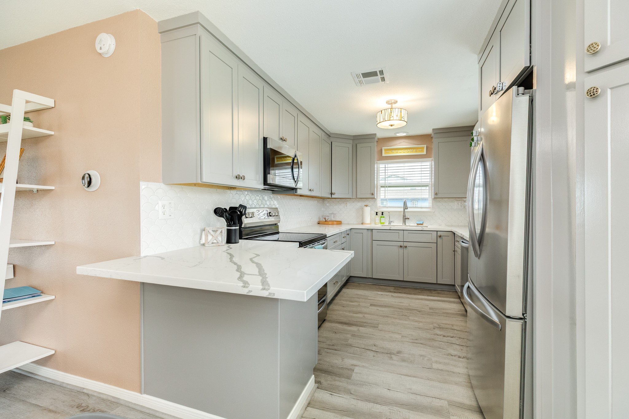 306 Pompano Lane Surfside Beach, TX 77541 - Photo 18 of 37 a kitchen with white cabinets and stainless steel appliances